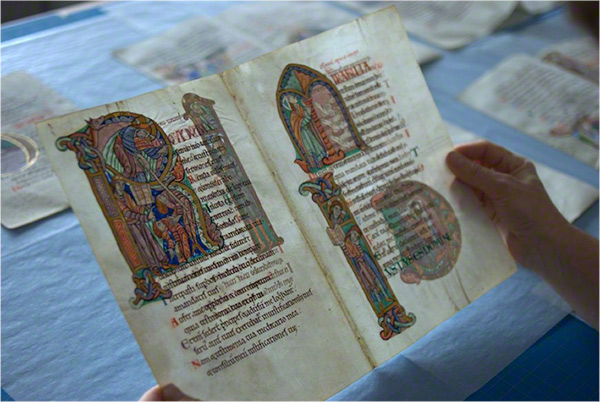 Conservator's hands holding the parchment of the St. Albans Psalter