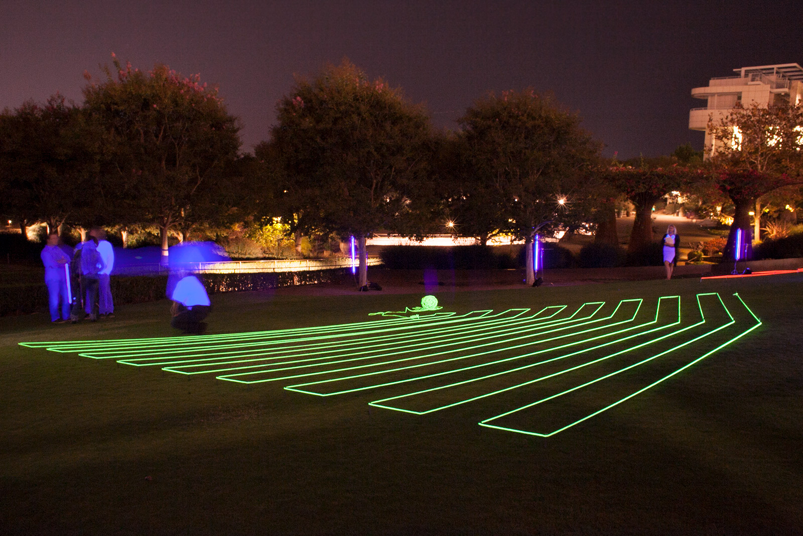 Nighttime view of a large lawn with thick, fluorescent-glowing rope arrayed in a geometric pattern