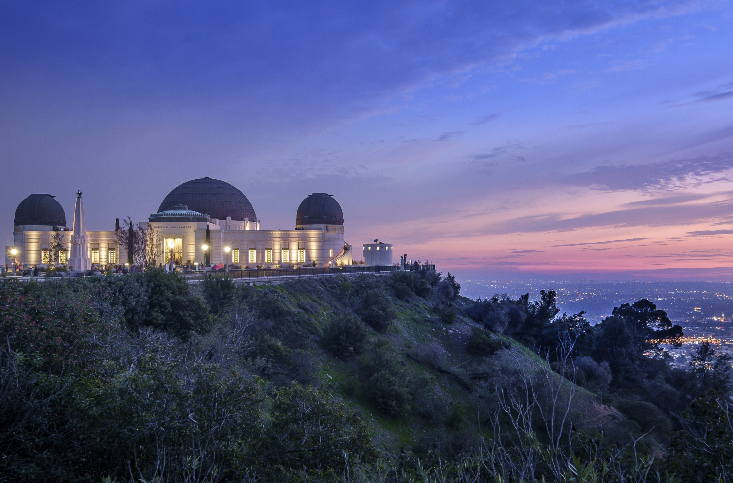 Griffith Observatory at sunset with the city of Los Angeles below to the left.