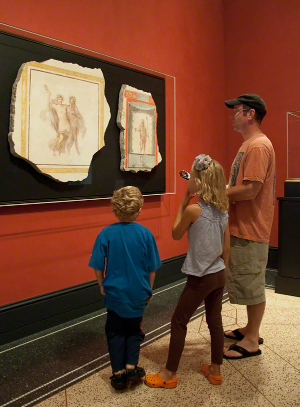 A family visiting the Getty Villa looks at Roman frescoes from Herculaneum