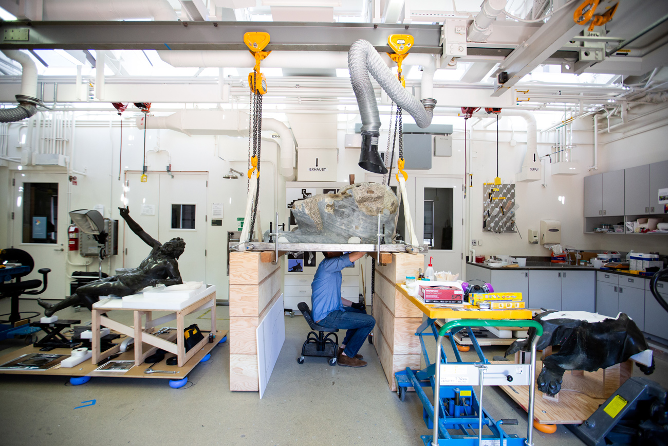 Erik works under the rock, with it propped up above his head.