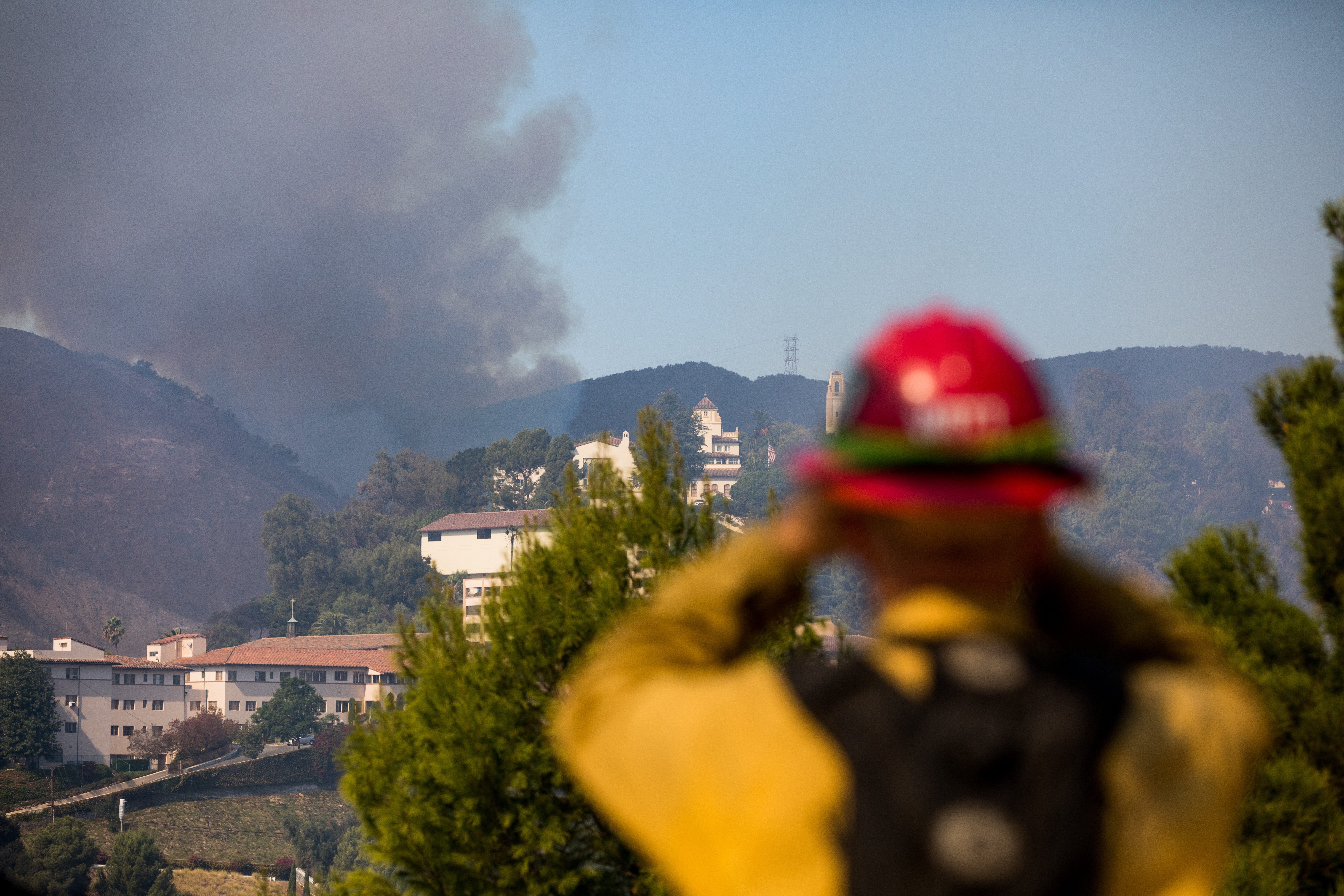 A firefighter helps coordinate response to a spot fire to the north of Mount Saint Mary's University, neighbor of the Getty Center to the north, on Monday. A firefighter helps coordinate response to a spot fire to the north of Mount Saint Mary's University, neighbor of the Getty Center to the north, on Monday.