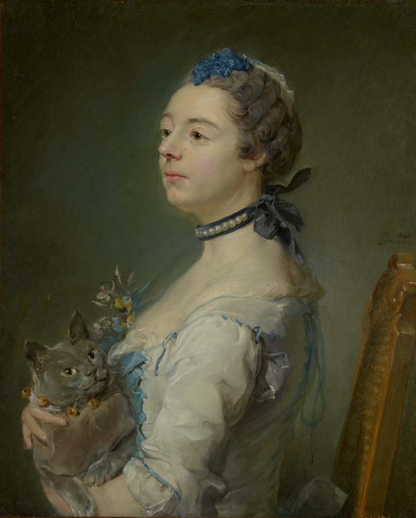 Portrait of a woman sitting facing left, holding a fluffy gray cat.