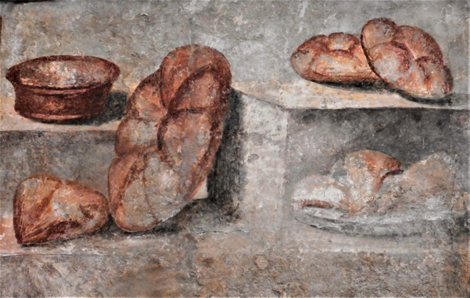 A pastel fresco, with brown round loaves of bread that sit on a shelf