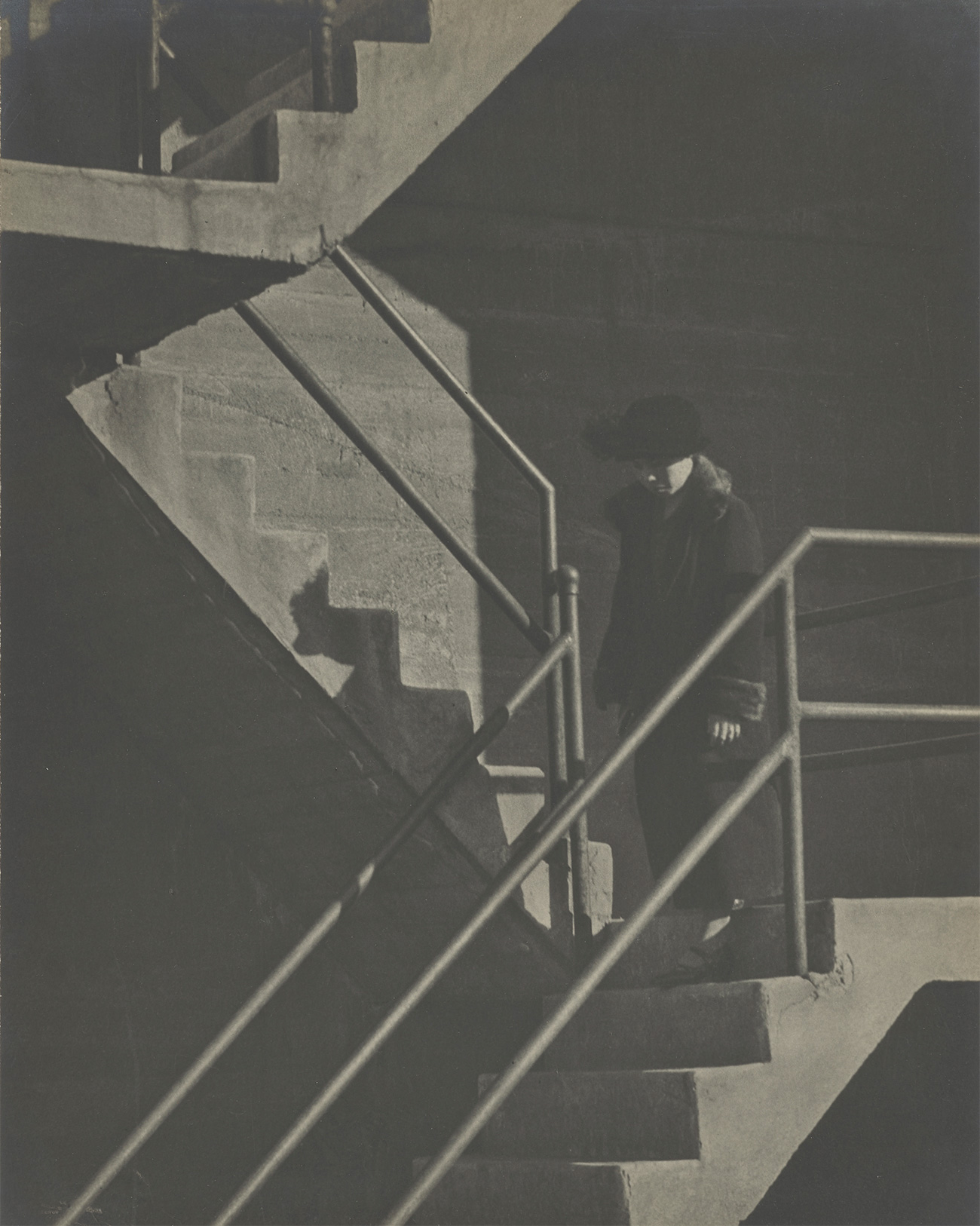 A person walks down the last of three flights of stairs