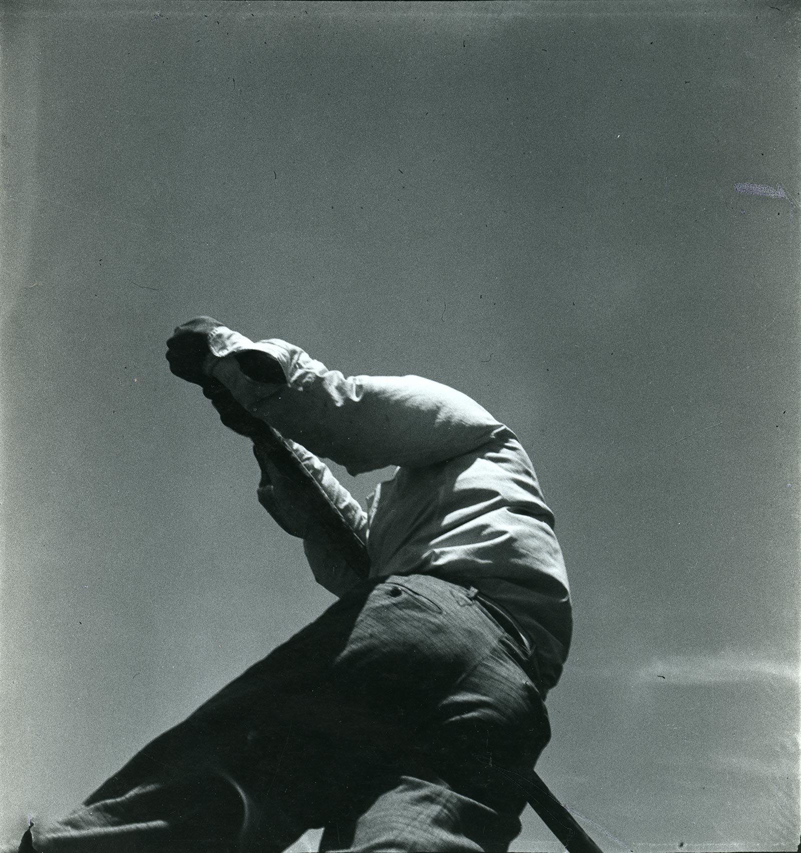 View from below of back side of person holding an oar