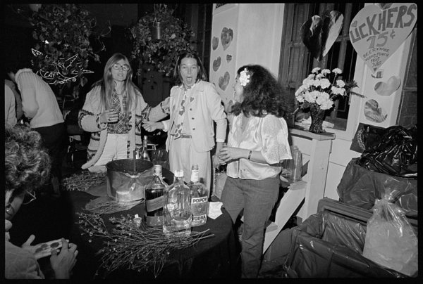 Three women stand around a punchbowl. A heart in the background says "Lickhers," a pun on liquors.