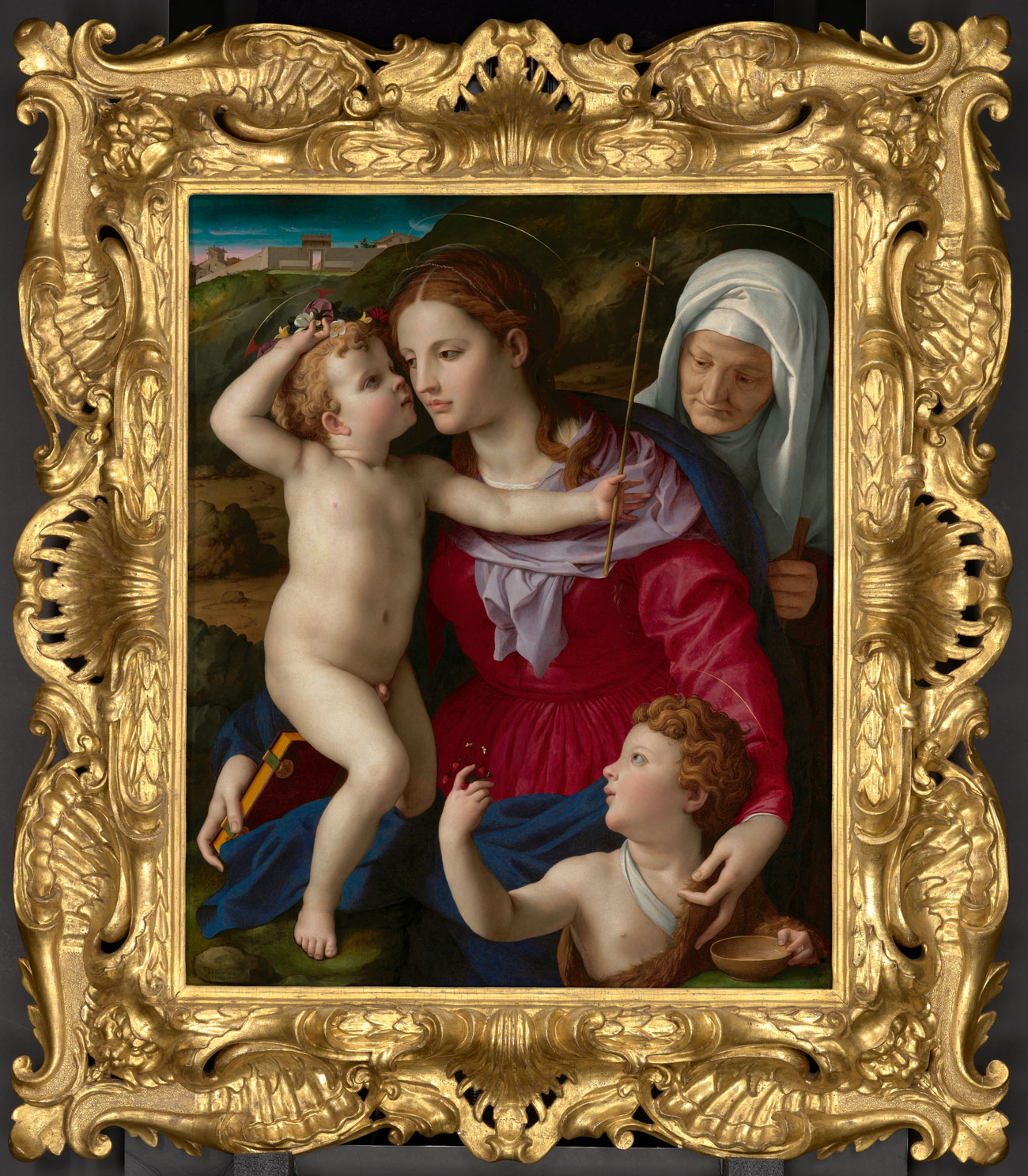 Elaborate gold frame around painting of woman holding two toddlers with an older woman peering over her shoulder