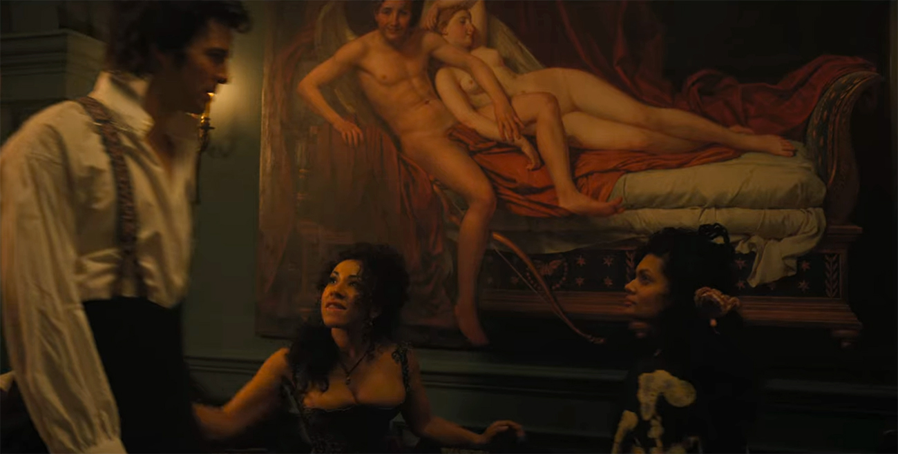 Still image from Bridgerton that shows a man and two women in front of a painting hanging on a wall; the painting depicts a nude man and woman lounging on a chaise