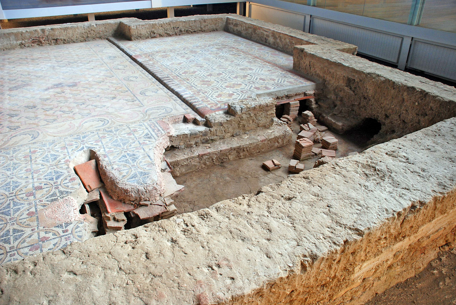 blue and pink tiled floor that is open to give a view of a stack of tiles