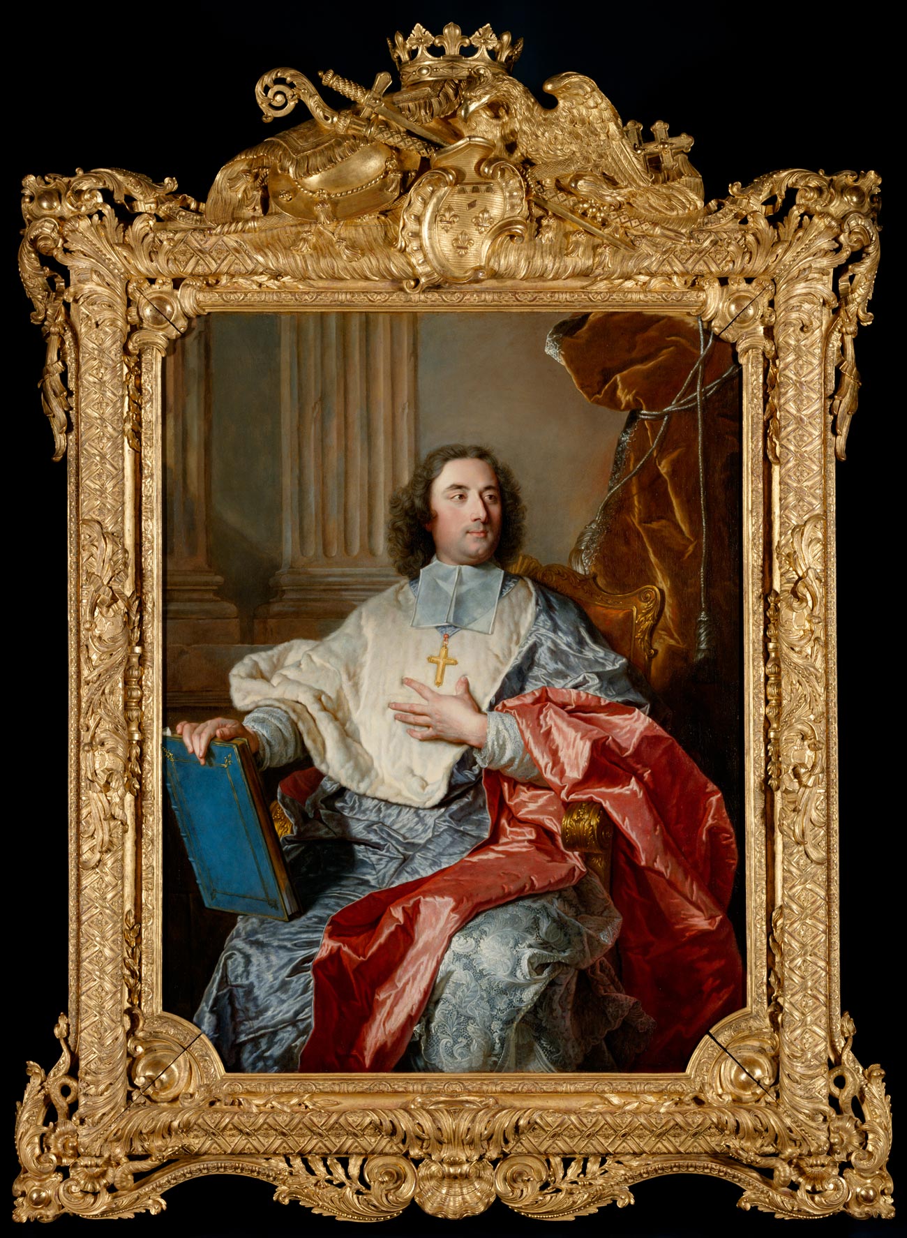 Painting of man wearing blue and red robes and a large cross necklace, holding a book, surrounded by an ornate gold frame