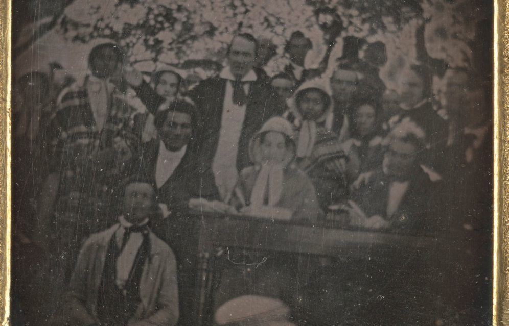 black and white image of people gathered around a podium