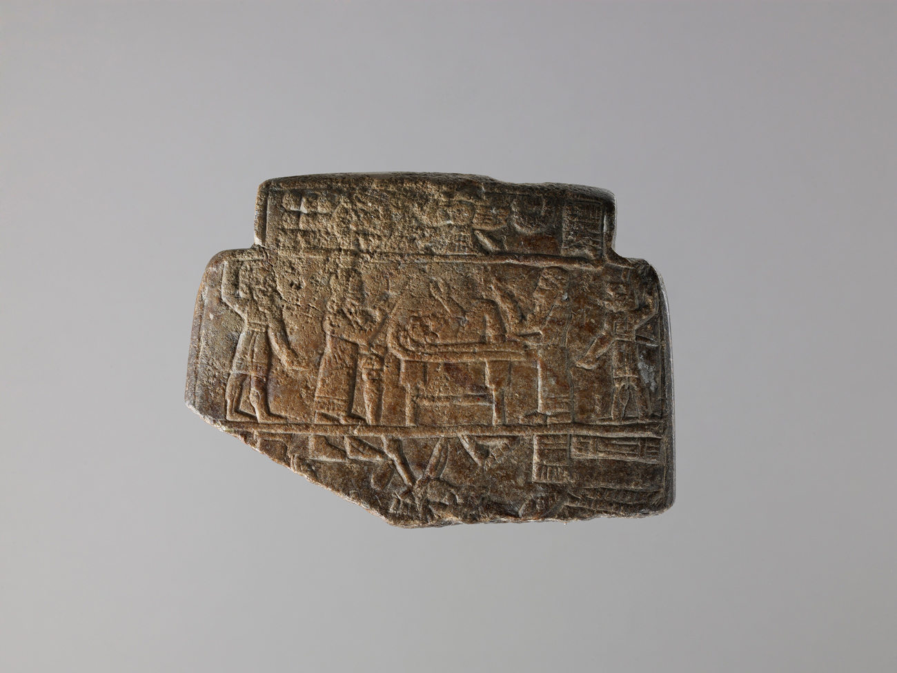 Piece of stone with broken corner, with engravings of figures and a demon