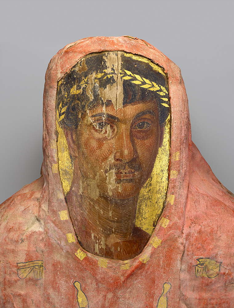 Faded red cloth encircles a face of man wearing a gold leaf headband.