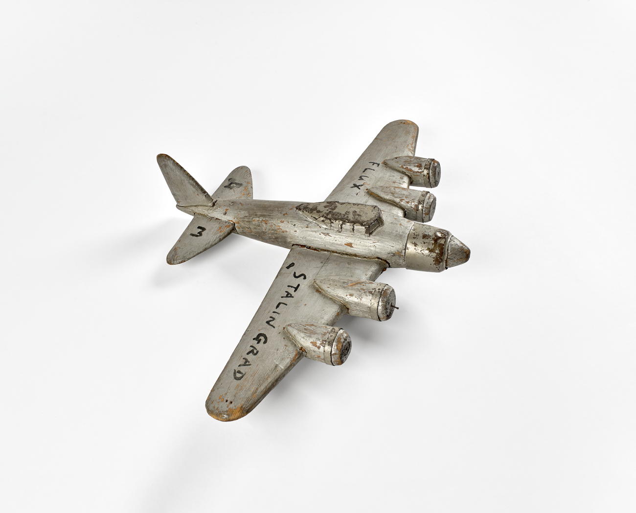 Small silver model airplane, with Stalingrad written on the wing
