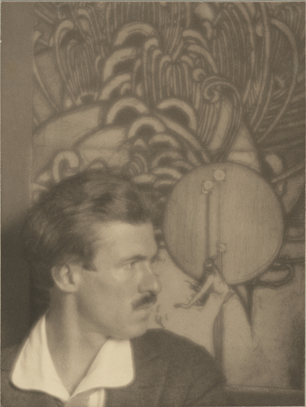 Roi Partridge, Etcher, 1915, Imogen Cunningham. Platinum print, 8 1/8 × 6 1/8 in. Getty Museum, 2019.107 © Imogen Cunningham Trust A photograph of a man shown in profiles in front of a large etching with a somewhat geometric pattern lots of semi-circles in it.