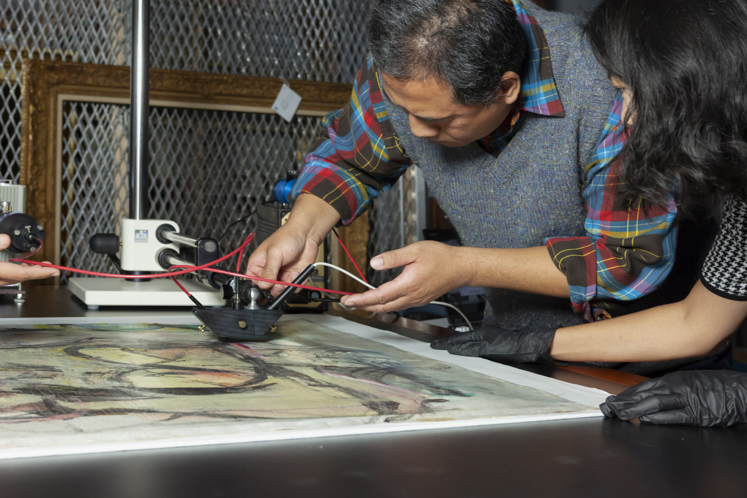 Associate Scientist Vincent Beltran and Getty Graduate Intern Hsiao-Hsuan Chao performing microfade testing on Woman-Ochre de Kooning's Woman-Ochre is on a table at the left while two people look at it closely using special imaging equipment